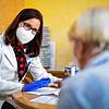 Eine Hausärztin spricht in ihrer Praxis mit einer Patientin, die wenig später ihre zweite Corona-Impfung erhält.