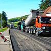 Etliche schwere Fahrzeuge sind im Einsatz, als am Pfohrener Ortseingang der Asphalt ausgebracht wird. Mit einem neuen Belag versehen ...