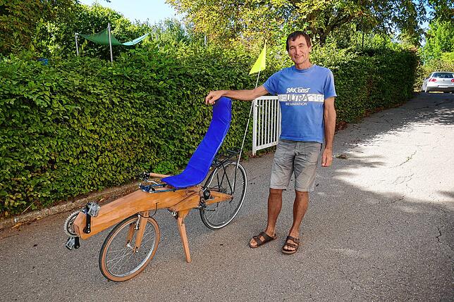 Mit sichtlicher Freude steht Martin Finsler neben seinem Holzliegefahrrad.