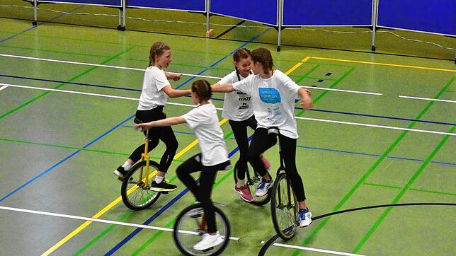 Kinder der Zirkus AG zeigen eine Choreografie auf dem Einrad. Foto: Rotraud Opfermann