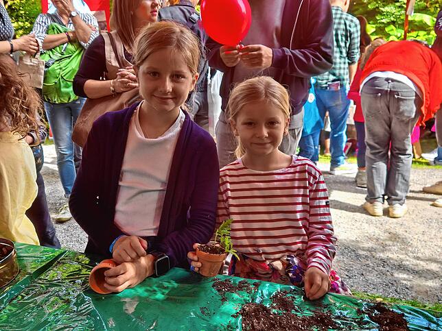Marie (10) und ihre Schwester Lisa (6) haben Spaß daran, Zebrakraut einzupflanzen.