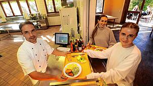 Der Küchen- und Mensa-Chef der Waldorfschule Überlingen, Christoph Zickmantel (von links), gibt das vegetarische Mittagessen an Elena ...