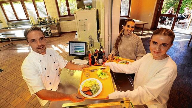 Der Küchen- und Mensa-Chef der Waldorfschule Überlingen, Christoph Zickmantel (von links), gibt das vegetarische Mittagessen an Elena ...
