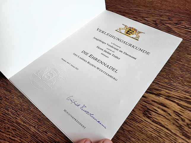 Mit Unterschrift von Ministerpräsident Winfried Kretschmann: Die Urkunde, mit der Stefan Traber für sein Ehrenamt ausgezeichnet wurde. ...