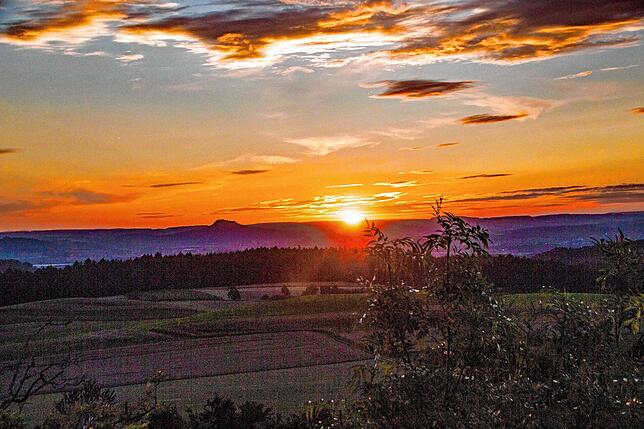 Die Hegau-Vulkane am Horizont von Duchtlingen aus Richtung Sonnenuntergang fotografiert.