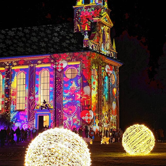 Ein Highlight: Die Fassade der Mainauer Schlosskirche ist bei „Christmas Garden“ mit einer bunten Projektion beleuchtet.