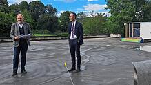 Stadtbaumeister Matthias Distler (links) und Bürgermeister Frank Harsch stehen auf der Bodenplatte des neuen Anbaus am Kinderhaus ...