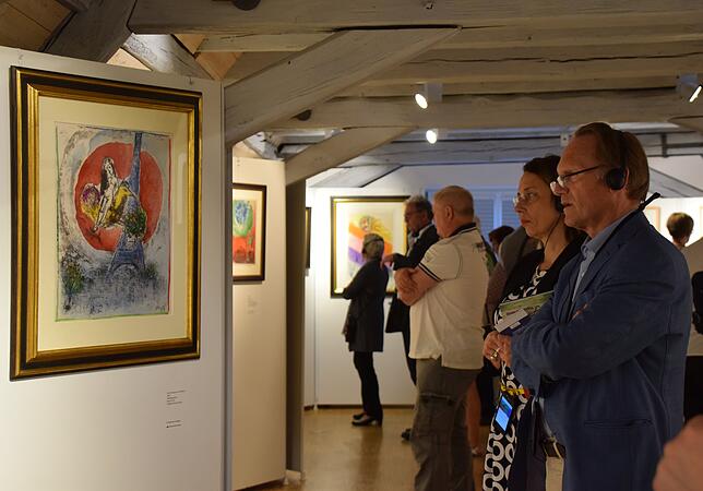 Besucher nutzten bei der Vernissage am Freitag den neuen Audioguide mit Kopfhörern. Links ist hier die Lithografie „Das Liebespaar ...