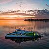 Katamaran Fridolin verlässt bei Sonnenuntergang den Hafen in Friedrichshafen.