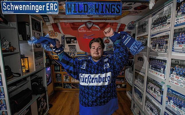 Patrick Lauer, Im Trikot und Schaal seines Lieblingsvereins zeigt begeistert seine gesammelten Fanartikel, die er in einem seiner beiden ...