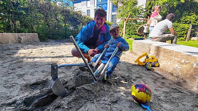Eddi und sein Vater Julian Frimmel testen den Bagger im neuen Sandkasten.