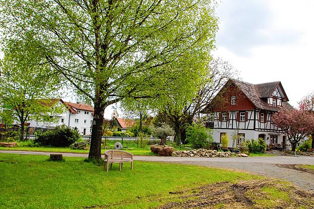 Blick von der Scheune auf das Backhaus. Links neben dem Backhaus liegt ein Gartenbereich, in dem ein Bauerngarten entstehen soll.