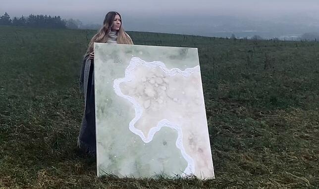 Die Malerin Paulina Vogt mit einem Kunstwerk aus ihrer Serie „Ein Gefühl von Heimat“, das noch in Arbeit ist.
