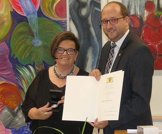 Anneliese Bendigkeit mit der Staufermedaille und der zugehörigen Urkunde, die sie von Oberbürgermeister Thomas Herzog überreicht ...
