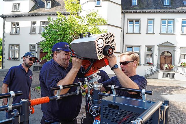 Frank Fischer und Mike Fröhlich entnehmen das elektrisch steuerbare Wenderohr aus der Halterung am Korb.