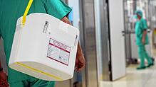 Ein Styropor-Behälter zum Transport von Organen wird an einem Operationssaal vorbei getragen.