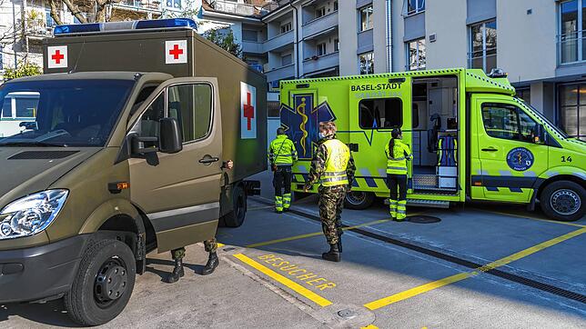 Ein Bild aus Basel, aufgenommen am 25. März 2020: Fahrzeuge der Sanität Basel und Sanitätsfahrzeuge des Militärs stehen an der Hebelstraße.