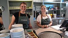 Café-Inhaberin Claudia Seifert und Steffi Schönemann, die im Service arbeitet, hinter der Theke des Café &bdquo;Dorfmädel&ldquo;.