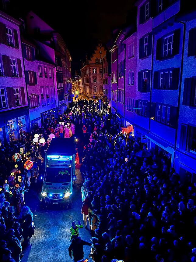 Einsatzkräfte halten beim Morgenstraich in Basel den Weg fürs Rettungsfahrzeug frei.