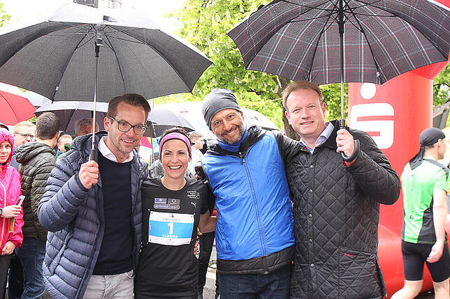 Gut beschirmt (von links): Florian M. Semet vom Halbmarthon-Sponsor Lakes Estates, Siegerin Sabrina Mockenhaupt, Organisator Markus ...