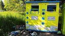 Vor dem Wertstoff-Container liegen einige Dinge wie Schuhe und Oberbekleidung, die eigentlich in den Container gehören. Doch auch ...