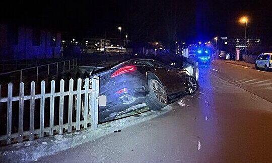 Der Wagen hat einen Zaun durchbrochen und ist an einem Mauervorsprung hängen geblieben.