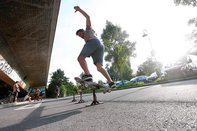 Direkt unter der neuen Rheinbrücke, wo tagsüber die Schulbusse ankommen, trainieren abends die Skater. Die Schanzen und Hindernisse ...