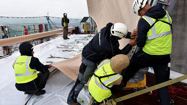 Arbeit bei Regen und Wind: eine Techniker-Crew bei der Montage der Textilfassade am Aufzugtestturm von Thyssenkrupp in Rottweil.