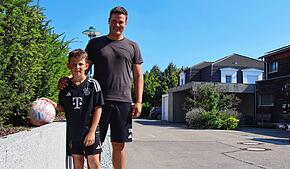 Elias Willibald (links) und sein Vater Sebastian Willibald, der Fußball und die Hecke. Hinten rechts: Der betroffene Carport.
