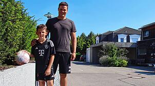 Elias Willibald (links) und sein Vater Sebastian Willibald, der Fußball und die Hecke. Hinten rechts: Der betroffene Carport.