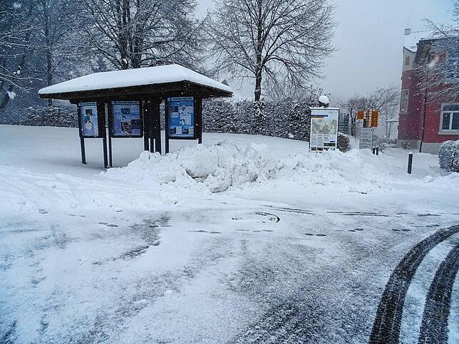 Am Rathaus (rechts im Bild) und den Ortsinformationstafeln türmt sich der Schnee.