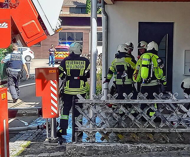 Die Atemschutzträger warten vor der verschlossenen Tür.