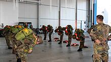 Die Gruppe, die aus dem übernächsten Flugzeug abspringt, bereitet sich im Sicherheitstraining noch einmal ganz konzentriert auf den ...