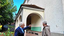 Der Dettinger Ortsvorsteher Roger Tscheulin (links) und Verwaltungsleiter Jürgen Morgen stehen vor dem alten Schulgebäude an der ...