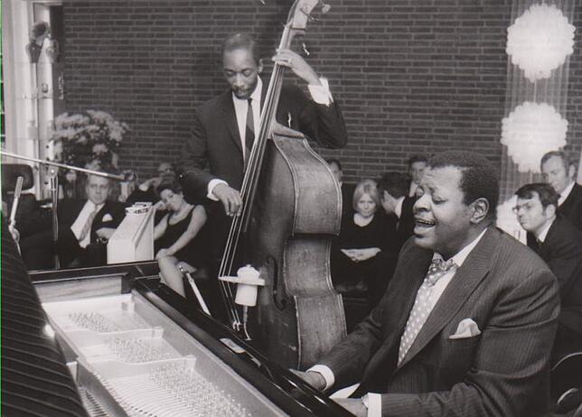 Haus-Konzert mit Oscar-Peterson am Flügel und Sam Jones am Bass. Rechts mit Brille: Eugen Cicero.
