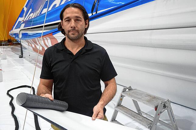 Casey L. Stohmeyer, Ingenieurmanager bei ILC Dover, hält den Folienstreifen, der in die Hülle des Zeppelin NT eingeschweißt wird.