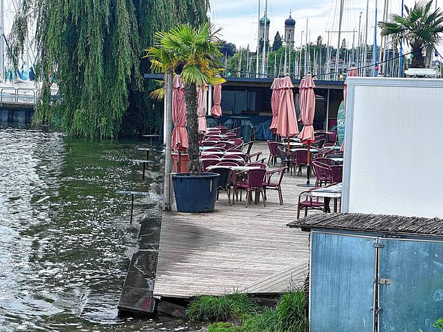 Die erste Tischreihe im Beachclub Friedrichshafen steht im Wasser.