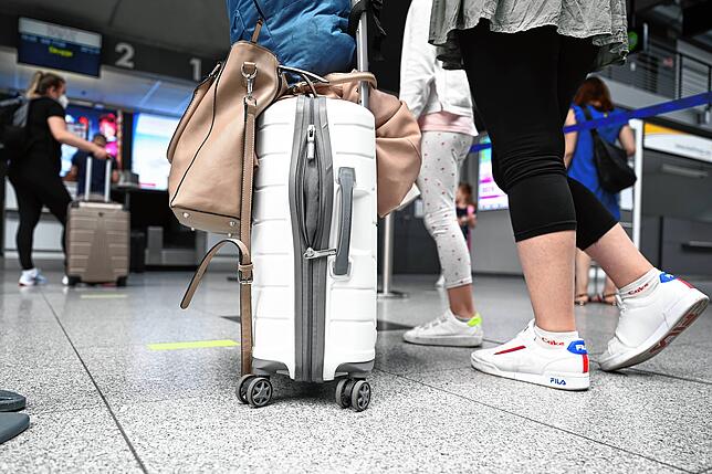 Passagiere stehen im Bodensee-Airport beim Check-in an.