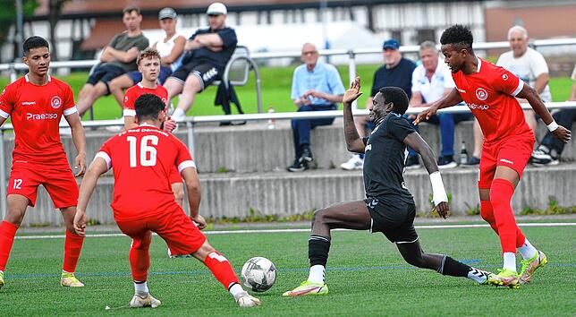 Obwohl Lewis Antebe (schwarzes Trikot) vom Gegner gehalten wird, gelingt es dem SC-Angreifer noch, den Ball mit langem Ausfallschritt zu ...