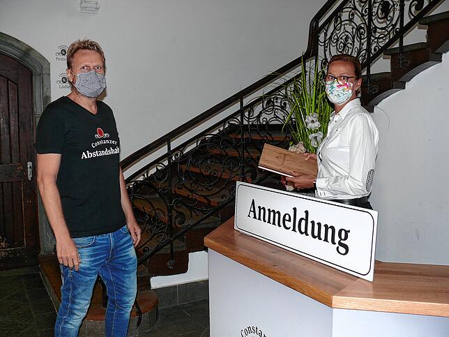 Tilo Irmisch und Restaurantleiterin Alexandra Glas zeigen eine Situation am Empfang. Jeder Gast muss zunächst seinen Namen eintragen ...