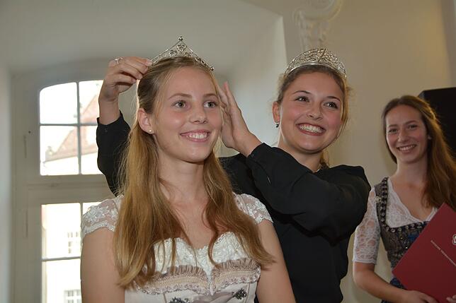 Die badische Weinkönigin Sina Erdrich (Mitte) krönt im Vestibül des Meersburger Neuen Schlosses die frischgekürte Bodenseeweinprinzessin ...