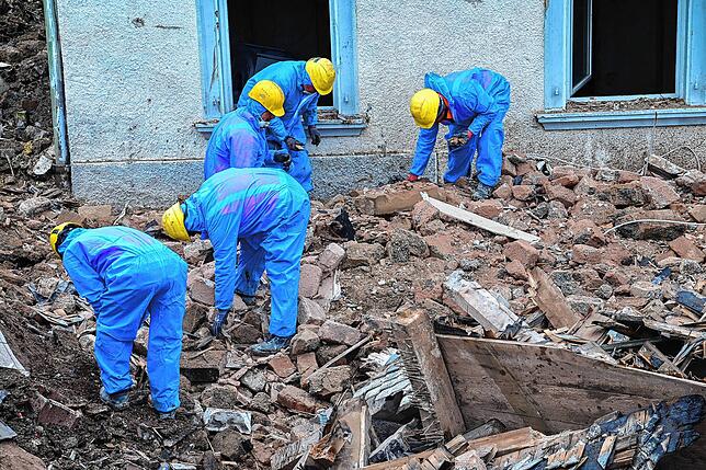 Arbeiter der Abrissfirma sortieren den Bauschutt.