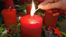 Eine Kerze am Adventskranz wird angezündet. Am 8. Dezember brennt schon die zweite.