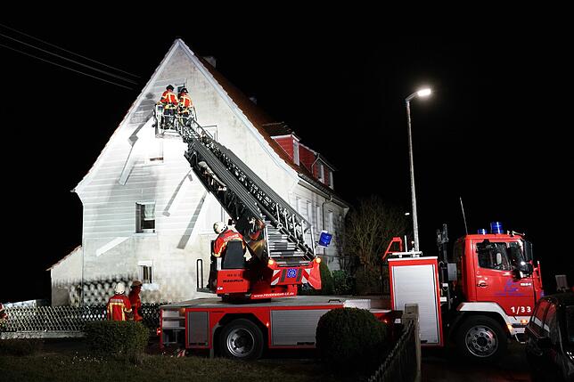 Feuerwehrleute arbeiten mit einer Drehleiter an einem Haus in Leinfelden-Echterdingen, dessen Fassadenverkleidung vom Sturmtief ...
