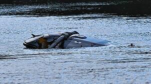 Ein Hubschrauber treibt in der Nähe von Grimma in Sachsen in einem Fluss.