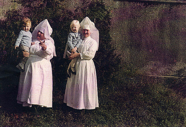 Kindergartenleiterin Schwester Hermann Joseph und Küchenschwester Euphronia mit zwei Stühlinger Kindern auf dem Arm in den 60er Jahren.