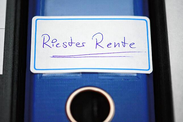 Ein Ordner mit einem Aufkleber Riester-Rente steht in einem Regal. Insgesamt rund 15 Millionen Riester-geförderte Vorsorgeprodukte sind ...
