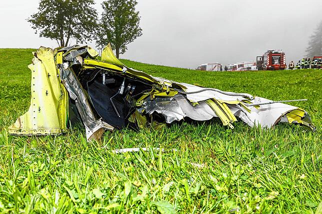 Ein Flugzeugteil liegt auf einer Wiese.