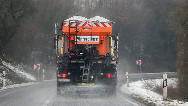 Ein mit Streumittel beladenes Fahrzeug des Winterdienstes fährt auf einer Straße. (Symbolbild)