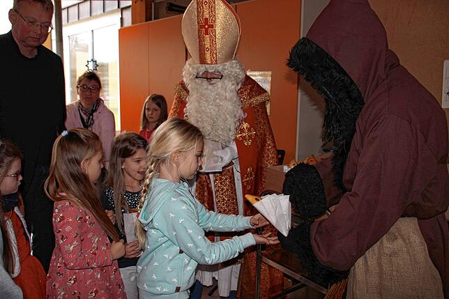 Jedem Grundschüler überreichten Nikolaus und Knecht Ruprecht einen Weckmann. Die Schülerinnen der 1. Klasse freuten sich darüber.